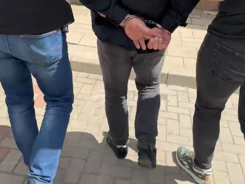 Policjanci prowadzą zatrzymanego mężczyznę