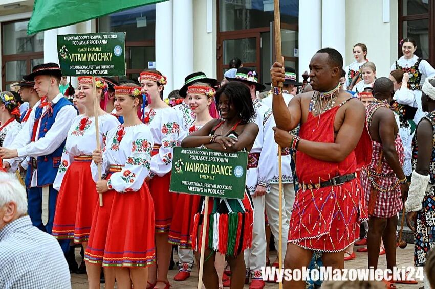 Wysokie Mazowieckie: zespoły folklorystyczne z tabliczkami przed korowodem pod Miejskim Ośrodkiem Kultury