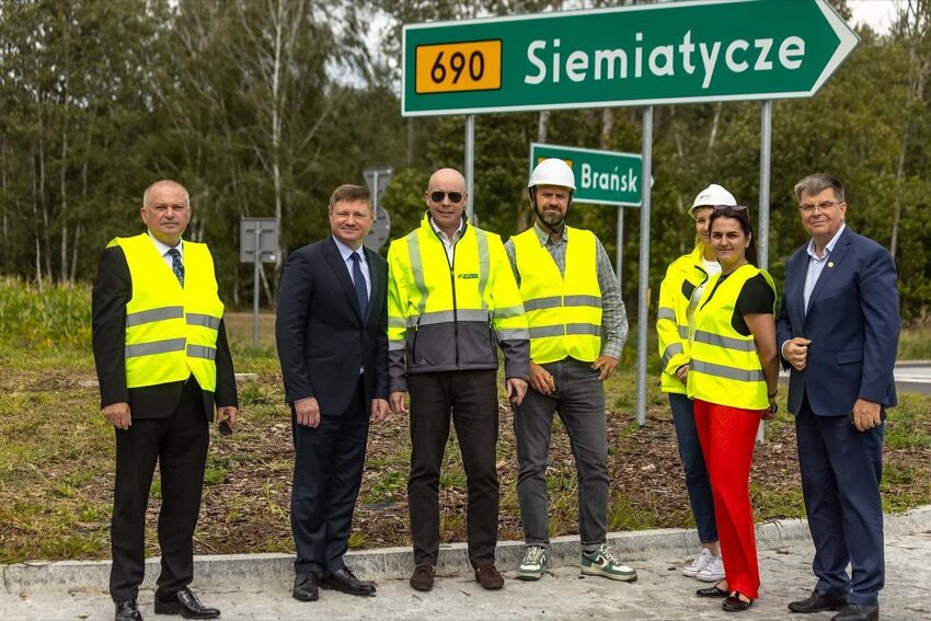 Ciechanowiec: uczestnicy otwarcia pierwszego odcinka obwodnicy pod tablicą kierunkową 690 Siemiatycze