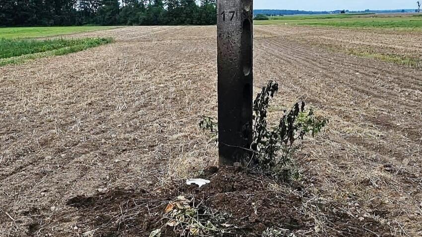 Jeńki: osmalony betonowy słup elektryczny na polu