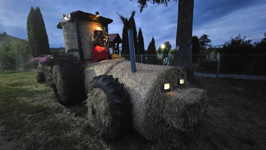 Nowe Żochy: słomiany traktor ze świecącymi reflektorami po zmroku
