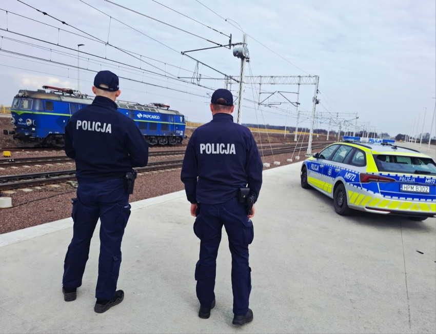 Policjanci na peronie przy torach, obok radiowóz - akcja Bezpieczny przejazd w powiecie wysokomazowieckim