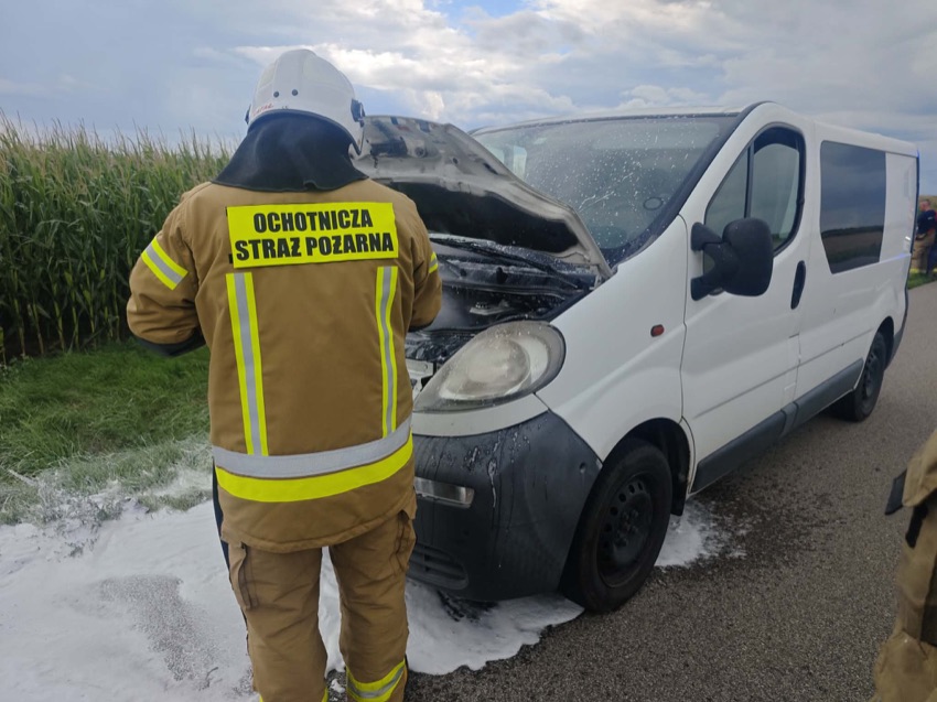 Strażak przy samochodzie z podniesioną maską, na drodze między Dąbrową Wielką a Czyżewem piana gaśnicza