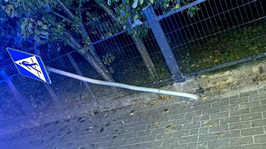 Ścięty znak przejścia dla pieszych przy ogrodzeniu posesji w Szepietowie po kolizji