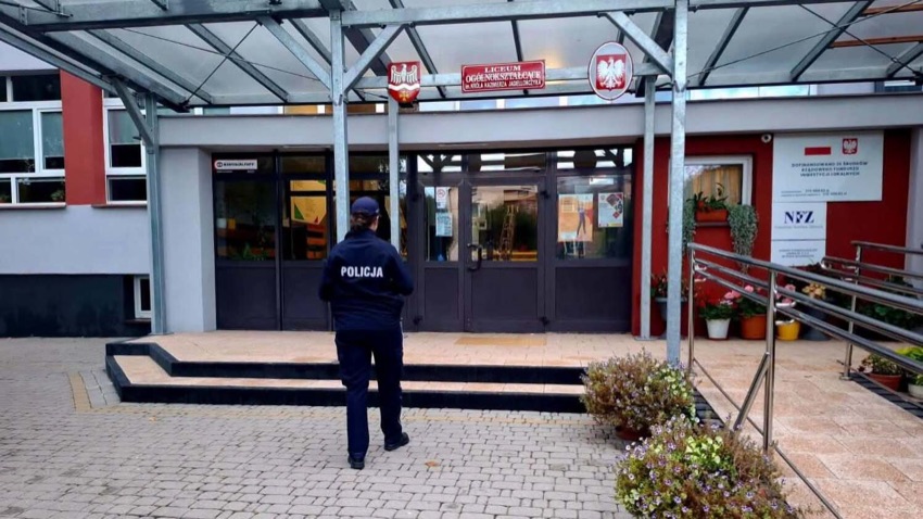 Policjantka przed wejściem do szkoły w Wysokiem Mazowieckiem