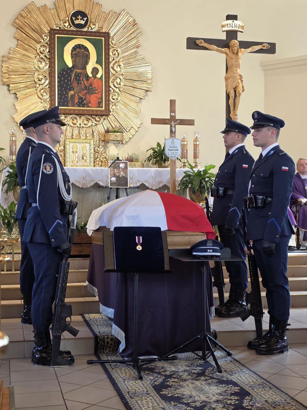 Trumna sierż. Natana Sieronia okryta flagą i policyjna warta honorowa w kościele w Rokitkach