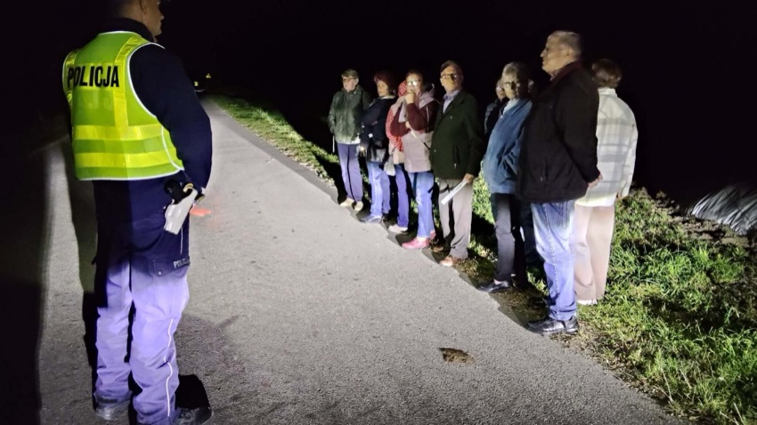 Policjant i seniorzy z Klubu Seniora na drodze po zmroku w Nowych Piekutach