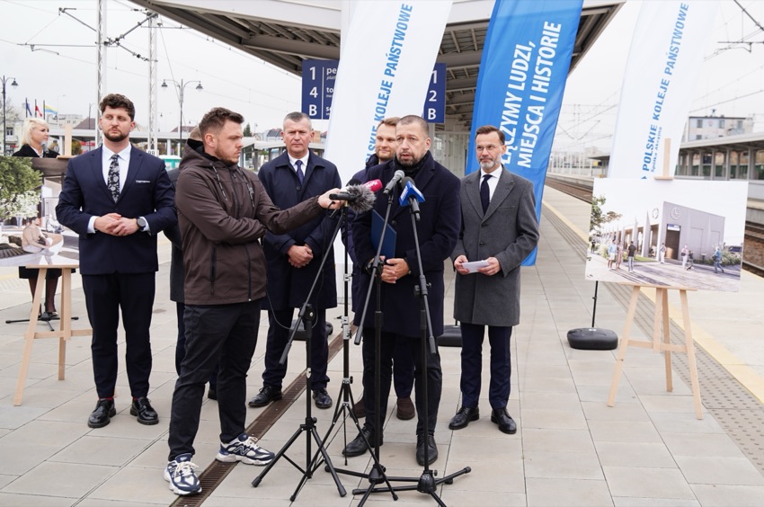 Konferencja prasowa PKP na peronie, obok wizualizacja dworca w Łapach