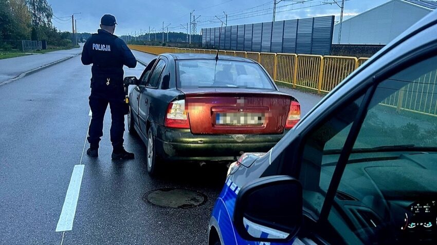 Policjant przy zatrzymanym Oplu podczas kontroli drogowej w Czyżewie