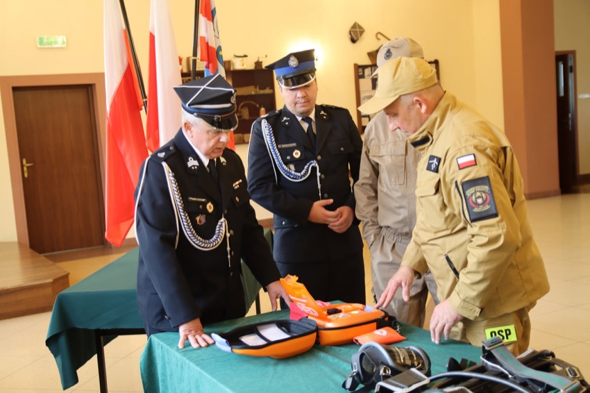 Druhowie OSP z gminy Nowe Piekuty oglądają nowy defibrylator AED w Izbie Tradycji Regionalnej