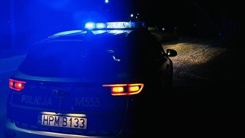 Radiowóz policyjny nocą z włączonymi światłami