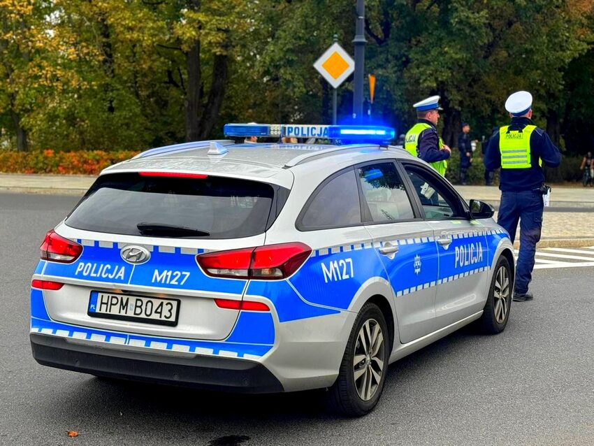 Radiowóz policyjny i policjanci na ulicy jesienią